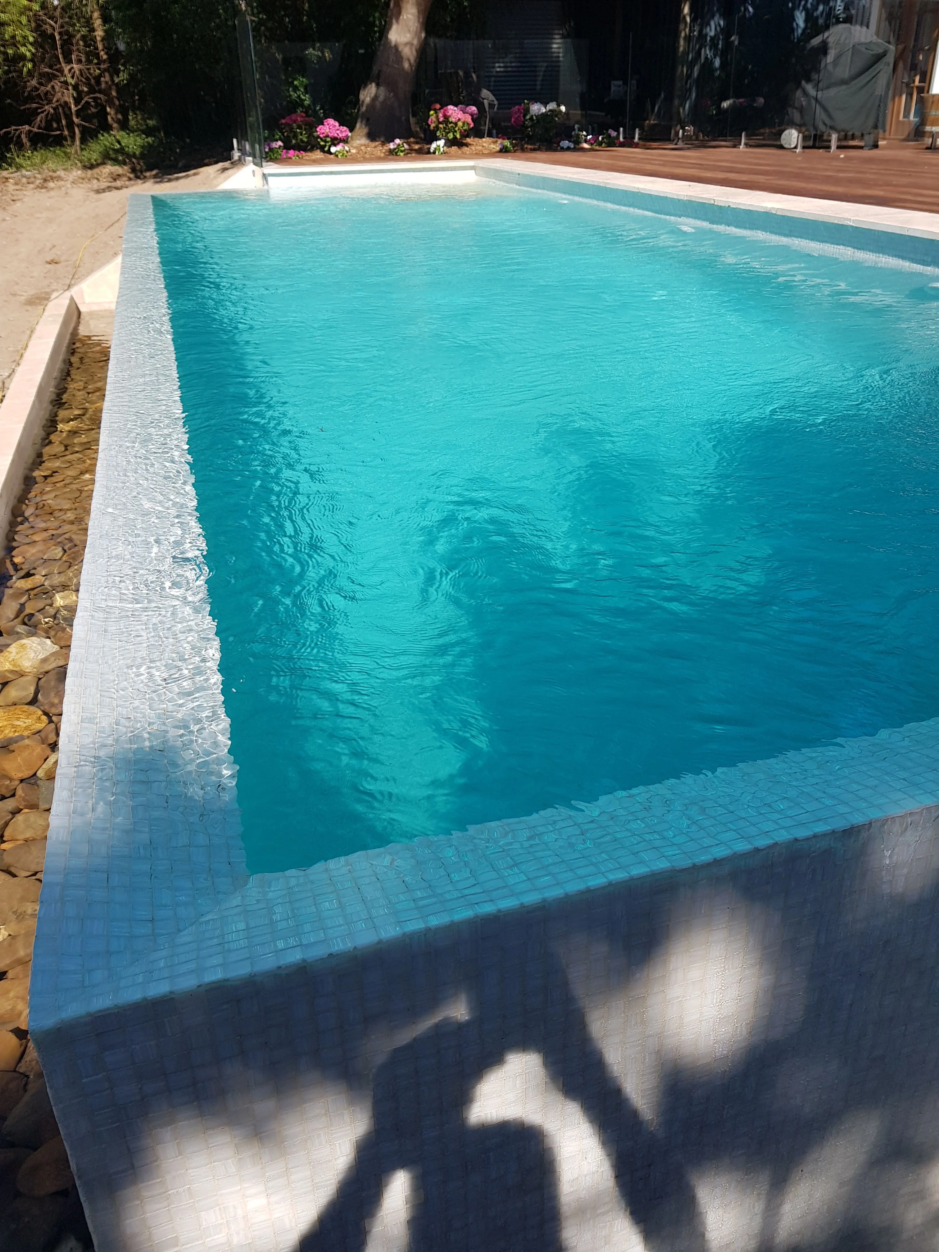 Close view along a finished pool showing clear turquoise water and the tiled waterline.
