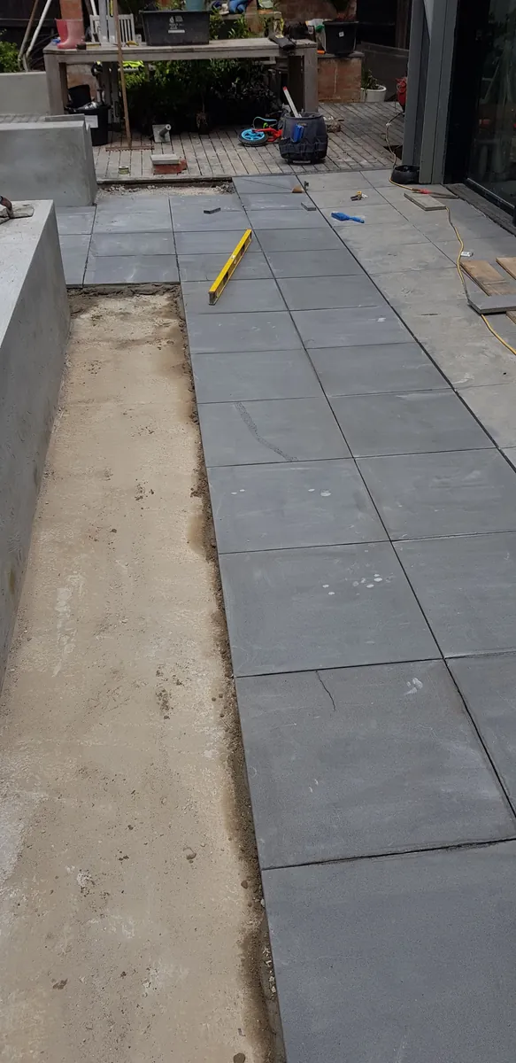 Grey pavers being laid on a prepared base