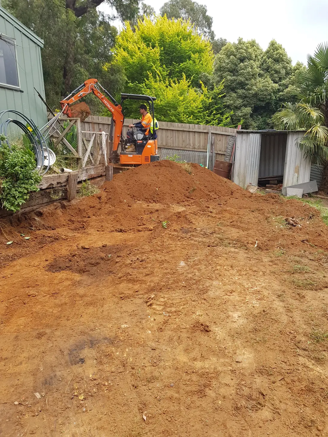 Excavator on a cleared residential site cut to level before construction